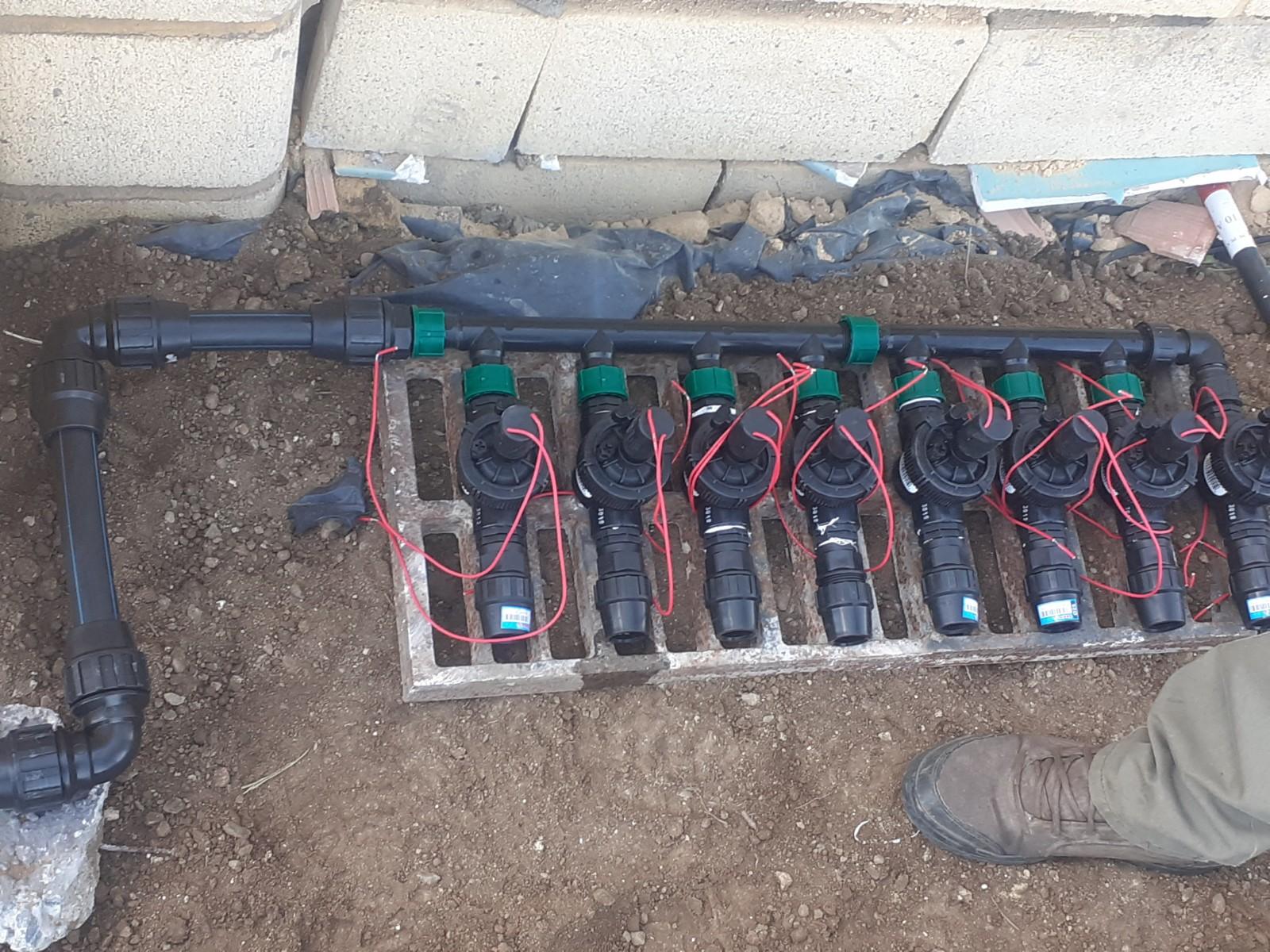 Colector de electroválvulas del riego por goteo montado en arqueta, con el cableado antes de cerrar la zanja