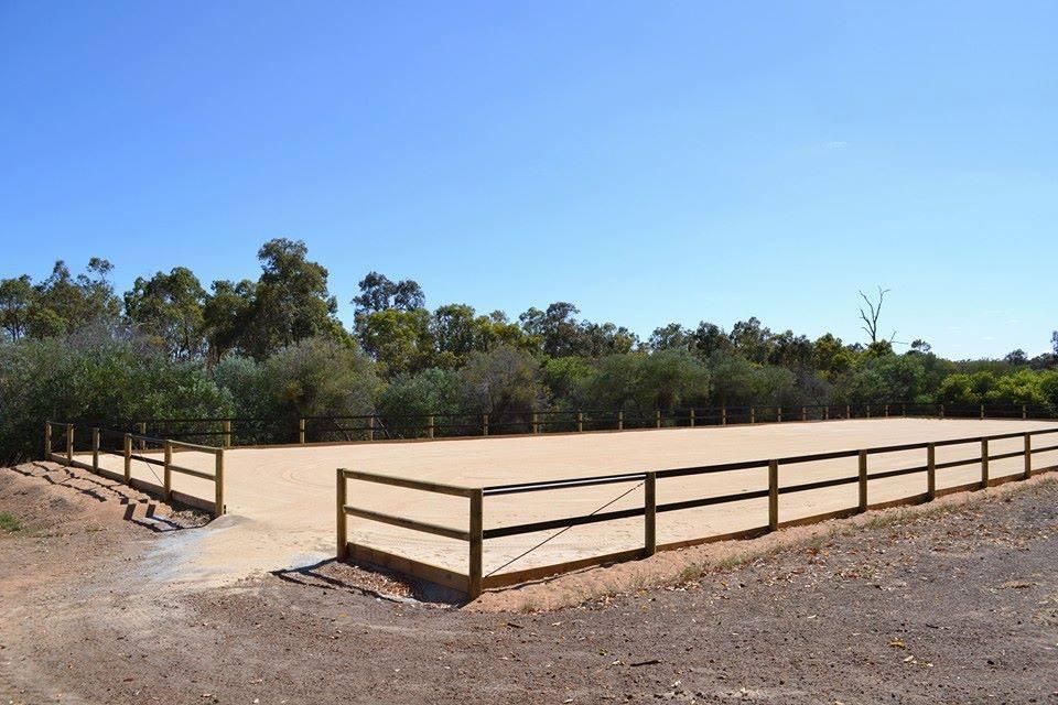 Pista de arena cerrada por completo con vallado de madera de tres alturas y tensores en diagonal